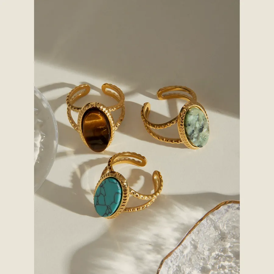 Three wide gold-tone band rings with an oval stone: tiger's eye, amazonite and turquoise.