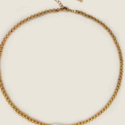 Collar de cadena dorada de eslabón redondo con una perla alargada montada en el frente.