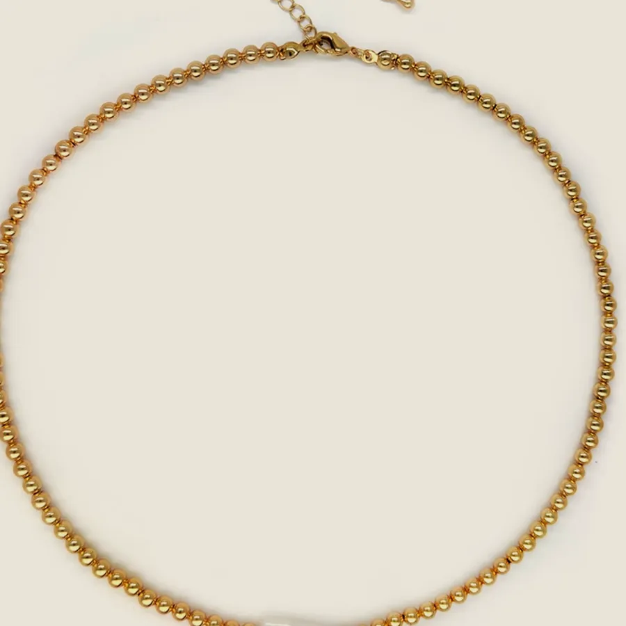 Collar de cadena dorada de eslabón redondo con una perla alargada montada en el frente.