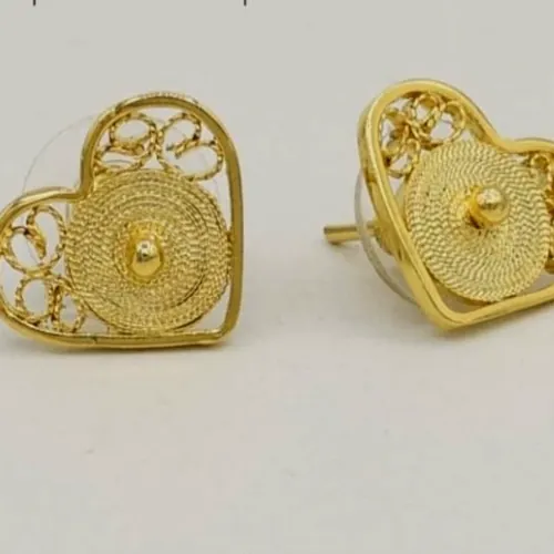 Aretes de filigrana dorada en forma de corazón con espirales concéntricas.
