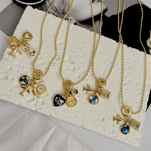 Varias cadenas finas doradas, cada una con un dije distinto: llave, lazo, medalla y gota azul.
