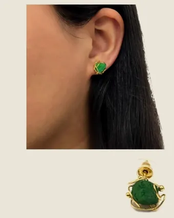 Raw emerald earring worn on the ear.