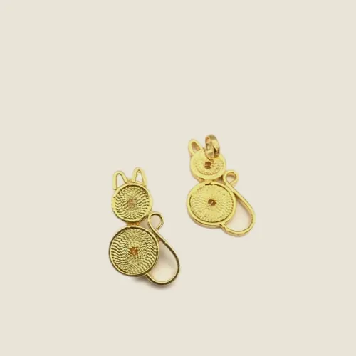 Aretes pequeños de filigrana dorada formados por dos espirales unidas.