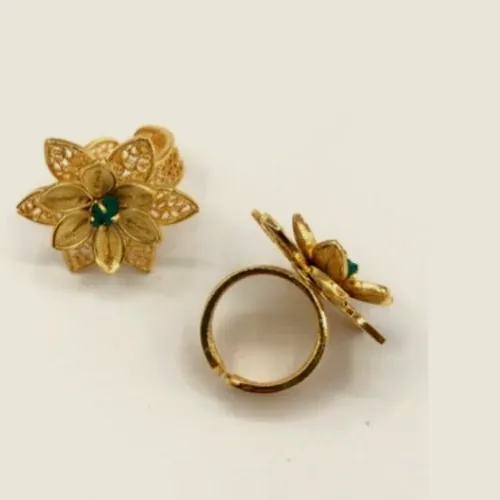 Anillo de filigrana dorada en forma de flor con esmeralda en bruto, visto de frente y de perfil.
