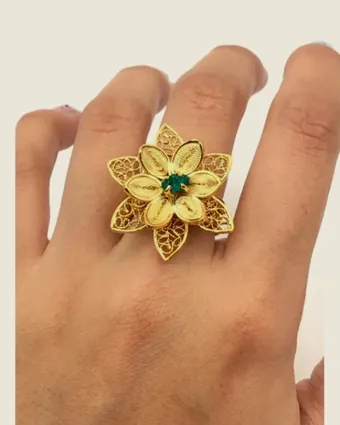 Filigree flower ring worn on the hand.