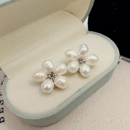 Aretes de flor formada por cinco perlas de agua dulce con centro de circonitas, en su estuche.