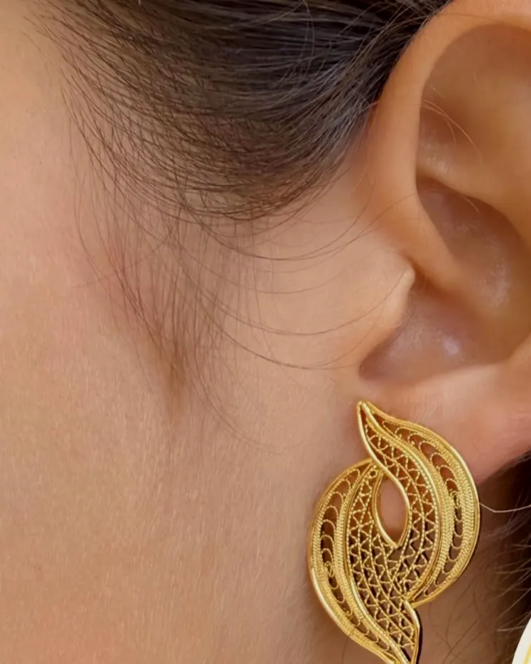 Filigree leaf earring worn on the ear.