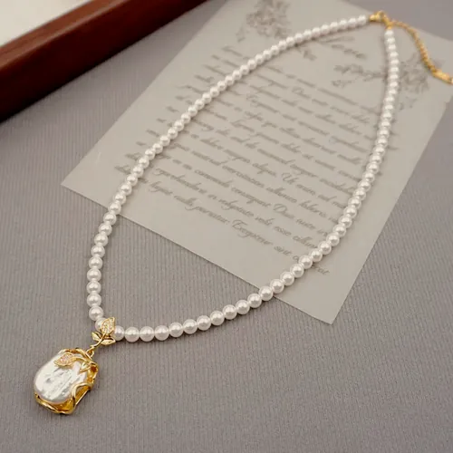 Collar de perlas pequeñas de agua dulce rematado por una perla barroca grande en garra dorada.