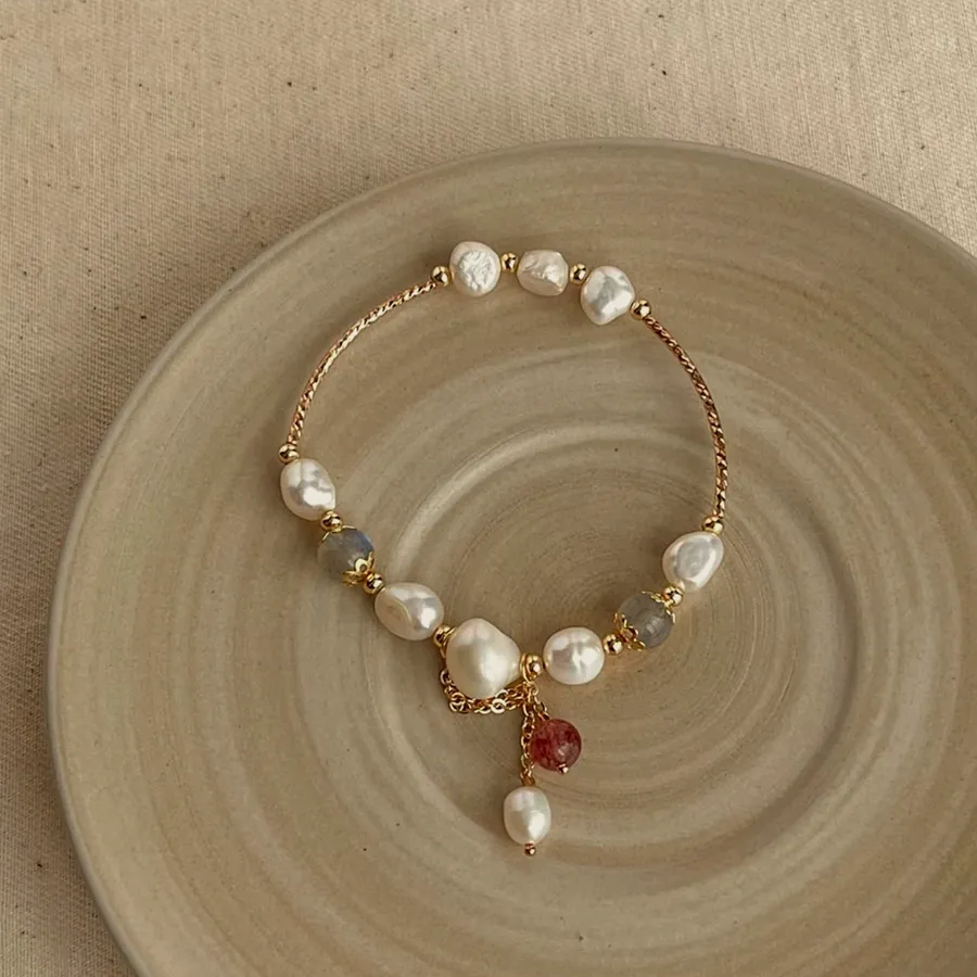 Bracelet of baroque pearls alternating with colour stones and a pearl hanging at the centre.