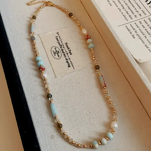Collar de cuentas de piedra de colores alternadas con perlas y separadores dorados.